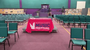 Kings Centre interior with rows of chairs and a table with Music Festival written on it